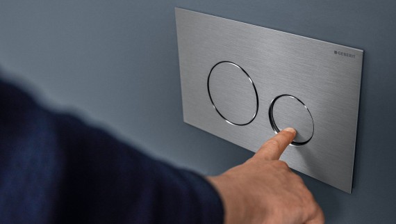 "Hånd aktiverer liten spyling på Sigma40 rund betjeningsplate (© Geberit) "Hånd aktiverer liten spyling på Sigma40 rund betjeningsplate (© Geberit)
